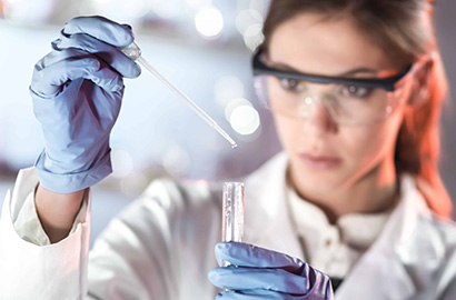 Woman in lab coat testing samples